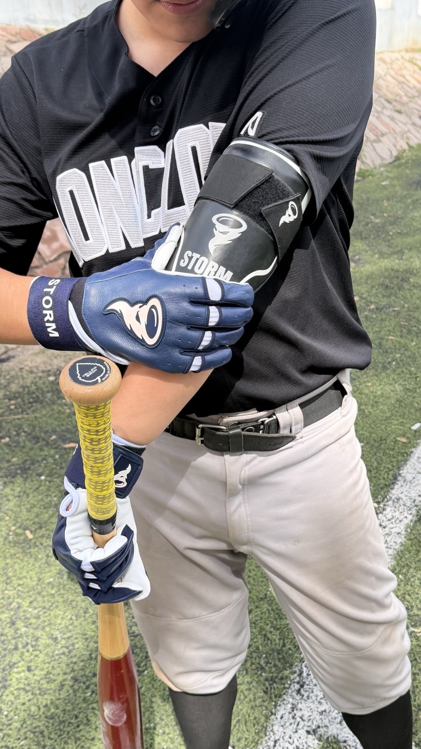 Pelotero usando guantes Storm navy y codera